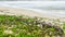 Big wave of blue ocean on sandy beach with plastic garbage and medical waste materials