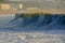 A big wave crashes on the beach