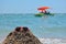 Big waves on the beach, ocean. Red and orange sunglasses lying on a sand slide built by a child on the beach