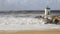 Big waves on a blocks jetty with a little lighthouse