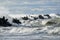 Big waves breaking over harbor breakwall concrete tetrapods