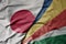 big waving national colorful flag of japan and national flag of seychelles