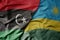 big waving national colorful flag of libya and national flag of rwanda