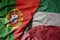 big waving national colorful flag of portugal and national flag of kuwait