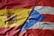 big waving national colorful flag of spain and national flag of puerto rico