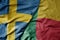 big waving national colorful flag of sweden and national flag of benin