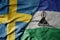 big waving national colorful flag of sweden and national flag of lesotho