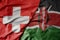 big waving national colorful flag of switzerland and national flag of kenya