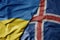 big waving national colorful flag of ukraine and national flag of iceland