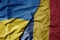 big waving national colorful flag of ukraine and national flag of romania