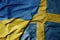 big waving national colorful flag of ukraine and national flag of sweden