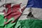 big waving national colorful flag of wales and national flag of lesotho