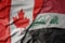 big waving realistic national colorful flag of canada and national flag of iraq