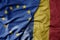 big waving realistic national colorful flag of european union and national flag of romania