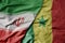 big waving realistic national colorful flag of iran and national flag of senegal