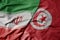 big waving realistic national colorful flag of iran and national flag of tunisia