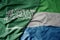 big waving realistic national colorful flag of saudi arabia and national flag of sierra leone