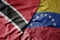 big waving realistic national colorful flag of trinidad and tobago and national flag of venezuela