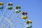 big wheel with multicolored cabins in amusement park
