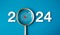 The big white 2024 year number with Target icon inside the golden magnifying glass on light blue background.