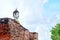 Big white cement buddha statue wearing a yellow coat and big old wall with blue sky, cloud, sunlight and tree at Wat Yai