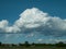 Big white and grey cumulus cloud over landscape