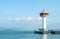 Big White and Orange Lighthouse with Boat at The Corner and Blue Sea and Sky in Background as Copyspace