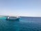 Big white ship, boat, cruise tourist liner on blue azure sea, ocean with reefs against the blue sky