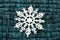 Big white snowflake on knitted wool background.