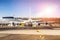 Big wide-body commercial passenger plane during maintenance and flight preparation at international airport. Service vehicles and