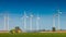 Big wind turbines to generate electrical power, green ecofriendly energy at blue sky standing at farm green field with working