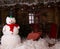 Big Winter Snowman on Decorated Wooden House