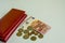 Big woman red wallet. Banknotes of 5 and 10 euros. Some coins