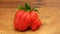 A big wonky red strawberry on a rustic wooden table top