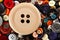 Big wooden button on sewing buttons background