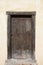Big wooden old door. Historical house door, one timber leaf, closed brown gateway.