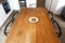 Big wooden table with chairs and cookies in the kitchen. Lonely white plate with cookies on an empty dinner table. Solid wooden