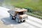 Big yellow dump truck working in the limestone open-pit. Loading and transportation of minerals in the chalk mining quarry.