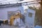 Big yellow excavator removal home building by destroy blue concrete wall. uproot old construction house for development new