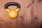 Big yellow kettlebell on a wooden background