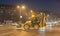 Big yellow loader bulldozer earth mover or digger construction machinery on the street with motion blur from driving night image
