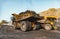 Big yellow mining truck laden anthracite moves open pit coal mine