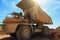 Big yellow mining truck at quarry at blue sky background