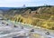 Big yellow mining trucks working in the limestone open-pit. Loading and transportation of minerals in the chalk open-pit.