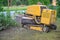 Big yellow stump grinder in lilac hedge