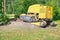 Big yellow stump grinder in lilac hedge