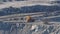 Big yellow trucks transport ore in an asbestos mineral quarry.