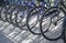 Biicycle rent Public bicycles, sharing bikes saddle. Detail view of a bike wheel with more bicycles lined up. Bicycle rent. Closeu