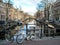 Bike on the bridge and reflection of Amsterdam famous duch traditional Flemish brick buildings on the canal