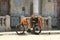 Bike of a Cuban onion street vendor overloaded with onions pictured with a dilapidated building on the background. A typical